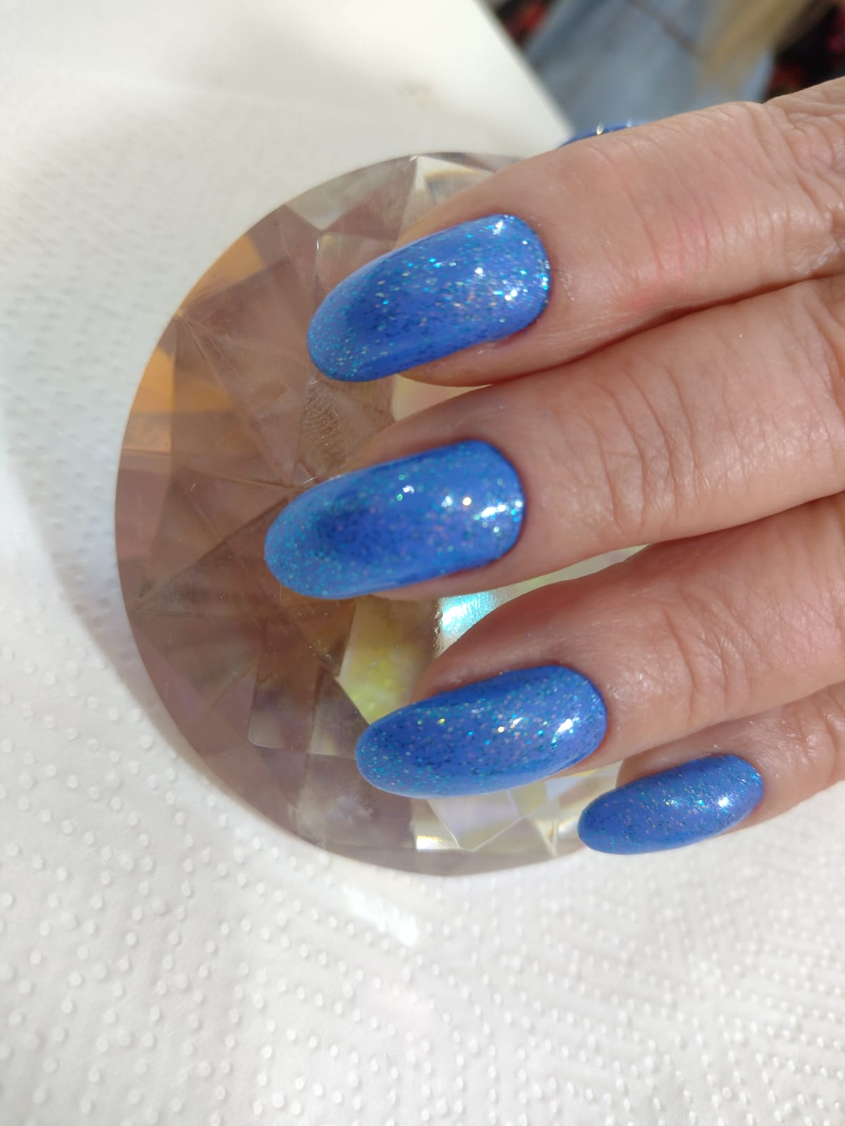 Alongamento de unhas com esmaltação azul e glitter, feito no Espaço Essência em Alvorada RS