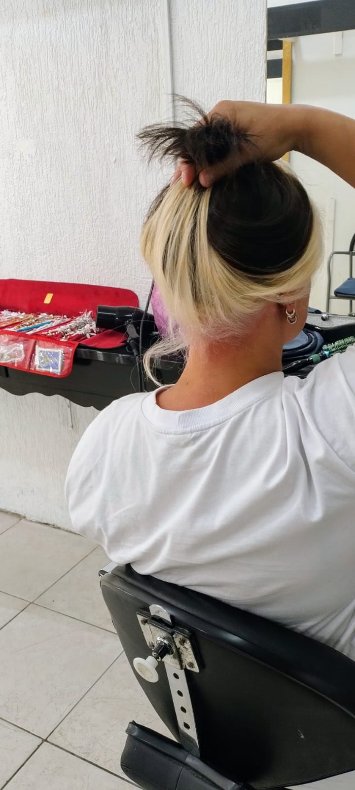Cabelo loiro com raiz escura preso, mostrando resultado de corte e coloração em Alvorada RS