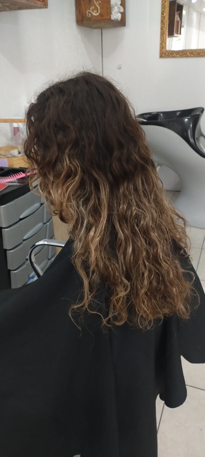 Corte em cabelo cacheado longo com iluminação nas pontas feito em Alvorada RS